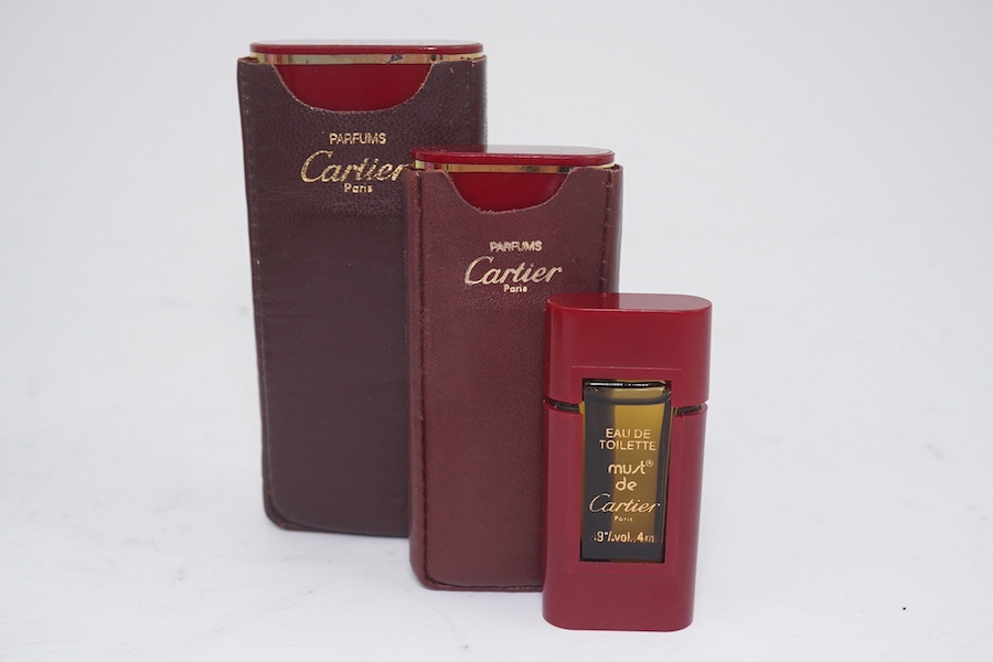 An assortment of Must de Cartier bordeaux leather accessories